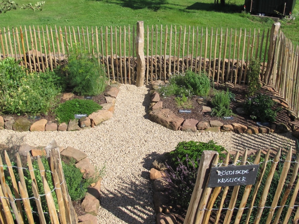 Ein Blick vom Eingang zum 6-Pfostenbau auf den Kräutergarten
